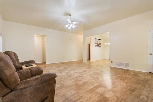 living room featuring visible vents, ceiling fan, light wood-style flooring, and baseboards