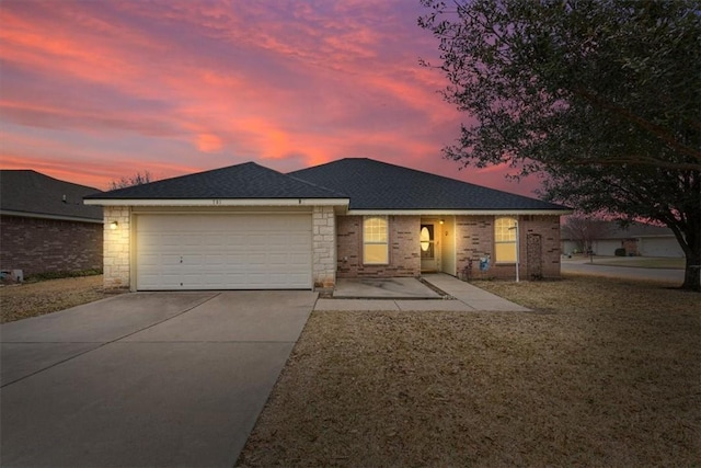 single story home featuring a front lawn, driveway, a shingled roof, and an attached garage