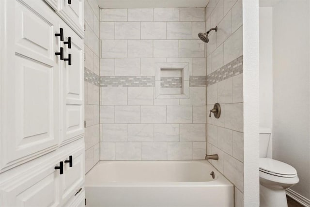 bathroom featuring toilet and tiled shower / bath