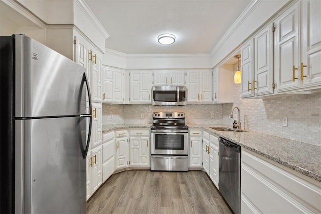 kitchen featuring appliances with stainless steel finishes, light stone counters, sink, light hardwood / wood-style flooring, and white cabinets