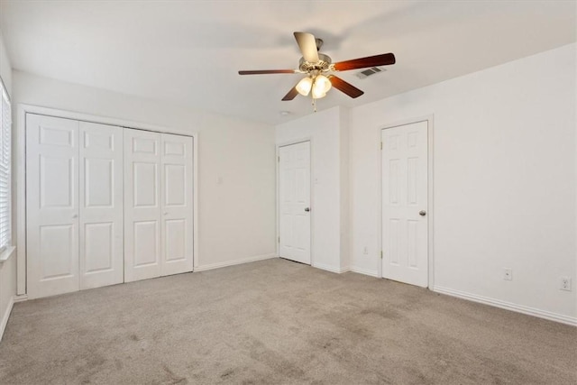 unfurnished bedroom with ceiling fan and light colored carpet