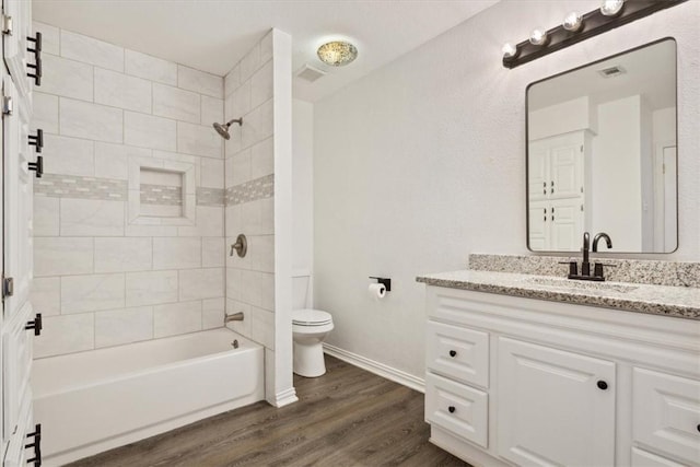 full bathroom with wood-type flooring, vanity, toilet, and tiled shower / bath