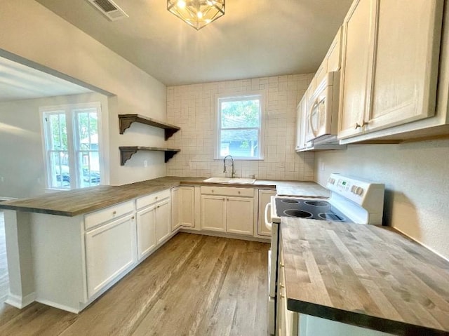 kitchen with white cabinetry, sink, wood counters, light hardwood / wood-style floors, and white appliances