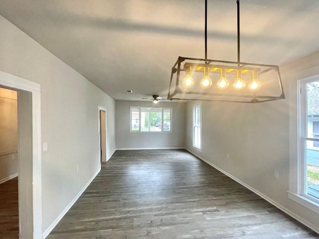 unfurnished dining area featuring a wealth of natural light, dark hardwood / wood-style flooring, and ceiling fan