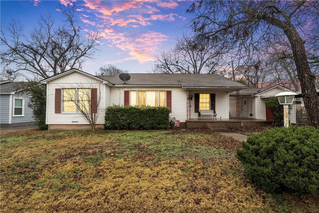 single story home featuring a yard and covered porch