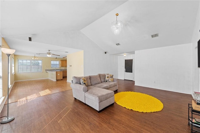 living room featuring ceiling fan with notable chandelier, hardwood / wood-style flooring, and high vaulted ceiling