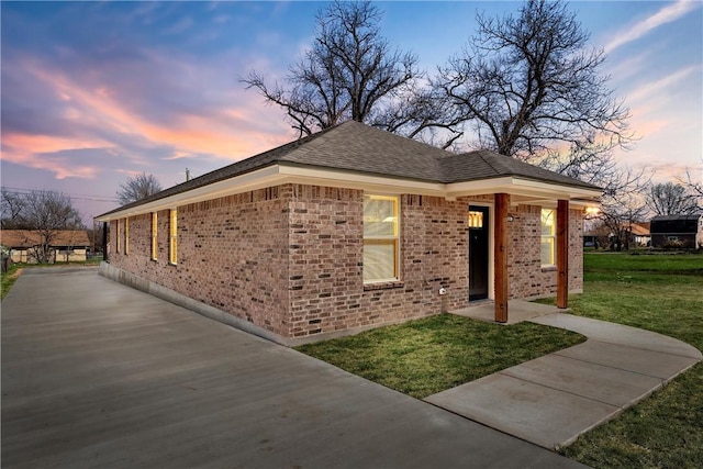 ranch-style home featuring brick siding and a front lawn