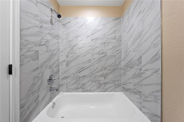 bathroom featuring shower / bathtub combination and a textured wall