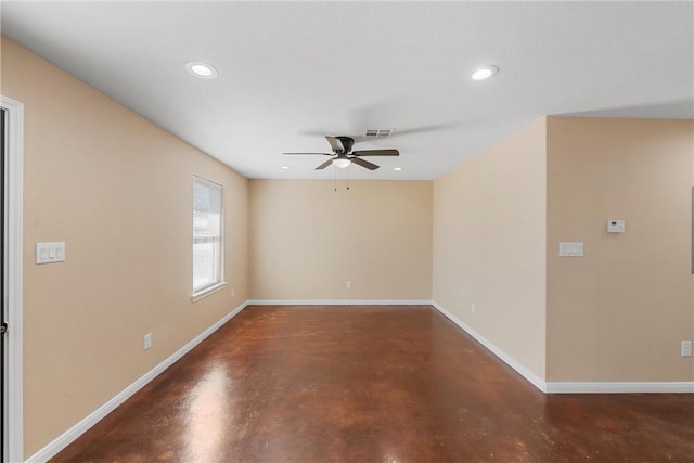 spare room featuring ceiling fan, visible vents, baseboards, and finished concrete floors