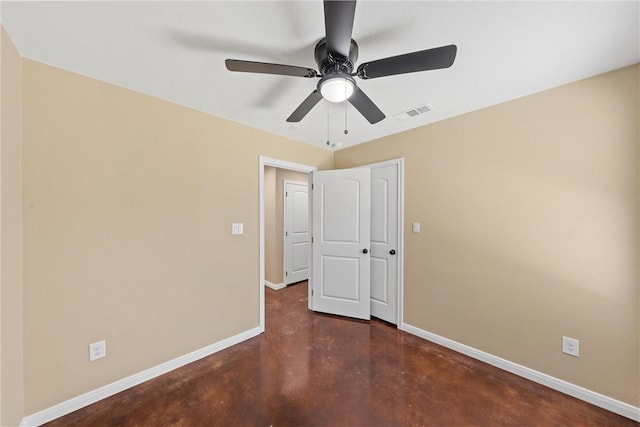 spare room with visible vents, baseboards, finished concrete flooring, and a ceiling fan