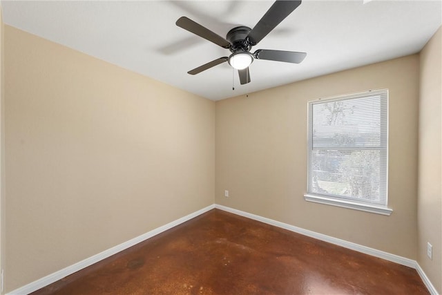 unfurnished room with a ceiling fan, concrete floors, and baseboards