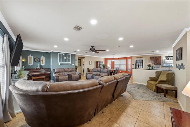 living room featuring crown molding, light tile patterned floors, and ceiling fan