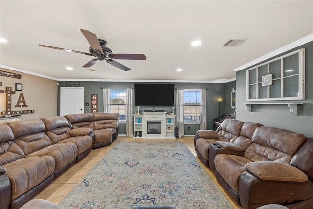 tiled living room with ceiling fan and crown molding