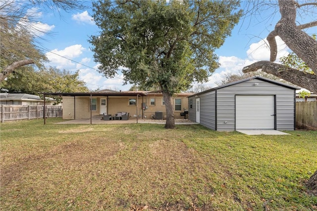 view of yard with a garage, an outbuilding, central air condition unit, and a patio area