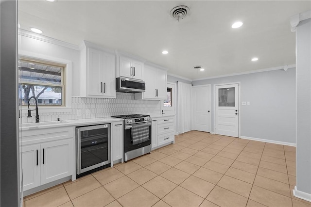 kitchen with sink, stainless steel appliances, beverage cooler, and white cabinetry