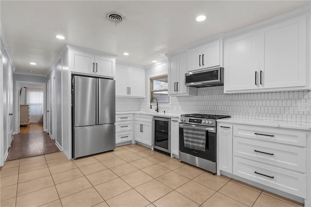 kitchen with stainless steel appliances, wine cooler, white cabinets, and sink