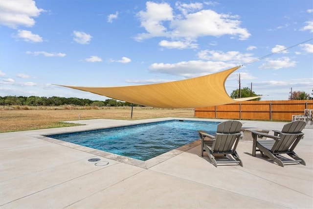 outdoor pool with fence and a patio area