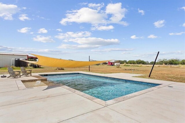 pool with a lawn and a patio area