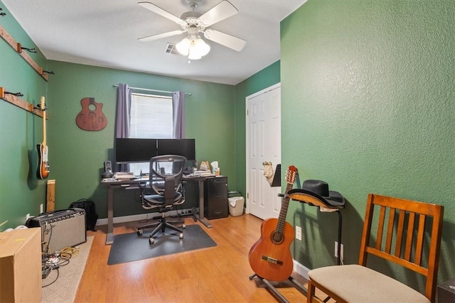 office featuring a ceiling fan, wood finished floors, visible vents, and baseboards