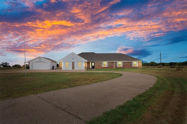 single story home featuring concrete driveway, an attached garage, and a front yard