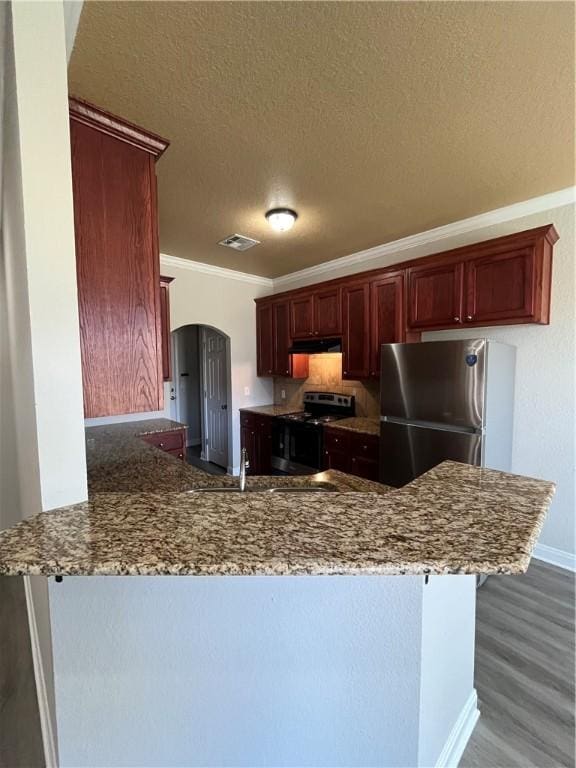 kitchen featuring kitchen peninsula, stainless steel fridge, electric range oven, ornamental molding, and a textured ceiling