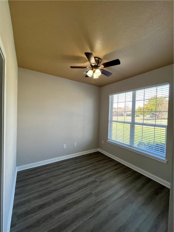 empty room with dark hardwood / wood-style flooring, a textured ceiling, and ceiling fan