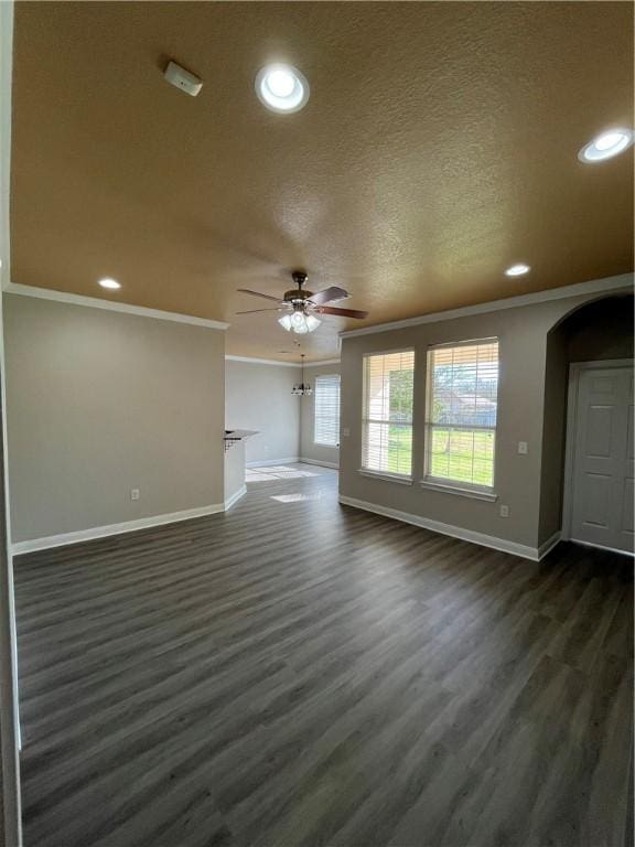 unfurnished living room featuring a textured ceiling, ceiling fan, dark hardwood / wood-style floors, and ornamental molding