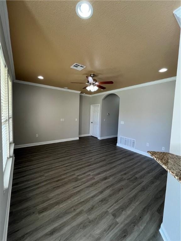 unfurnished living room featuring a textured ceiling, dark hardwood / wood-style flooring, ceiling fan, and crown molding