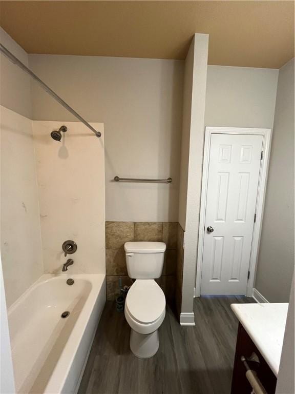 full bathroom with hardwood / wood-style floors, vanity, shower / bath combination, and toilet