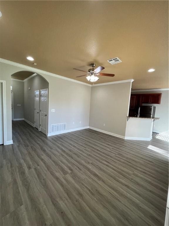 unfurnished living room featuring dark hardwood / wood-style floors, ceiling fan, and crown molding