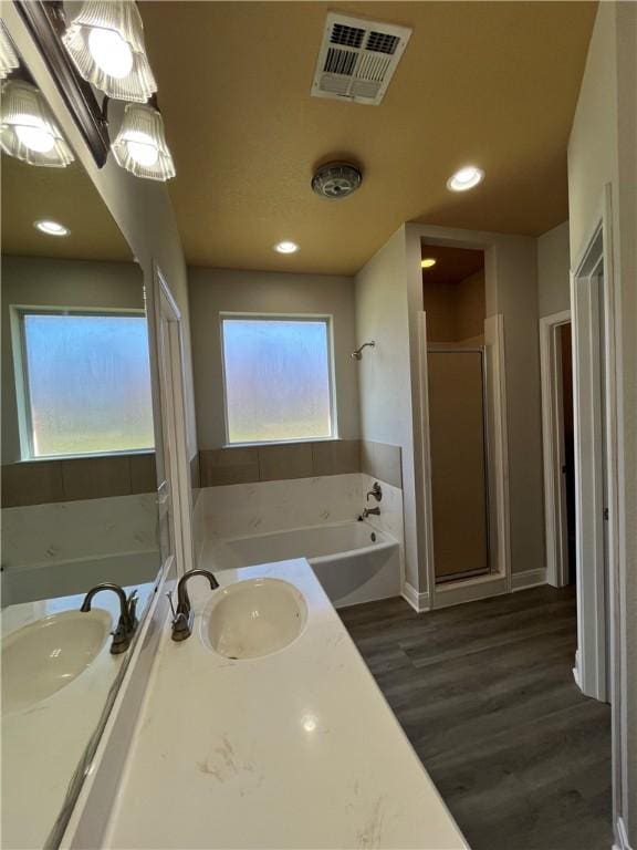 bathroom with wood-type flooring, vanity, shower with separate bathtub, and a healthy amount of sunlight