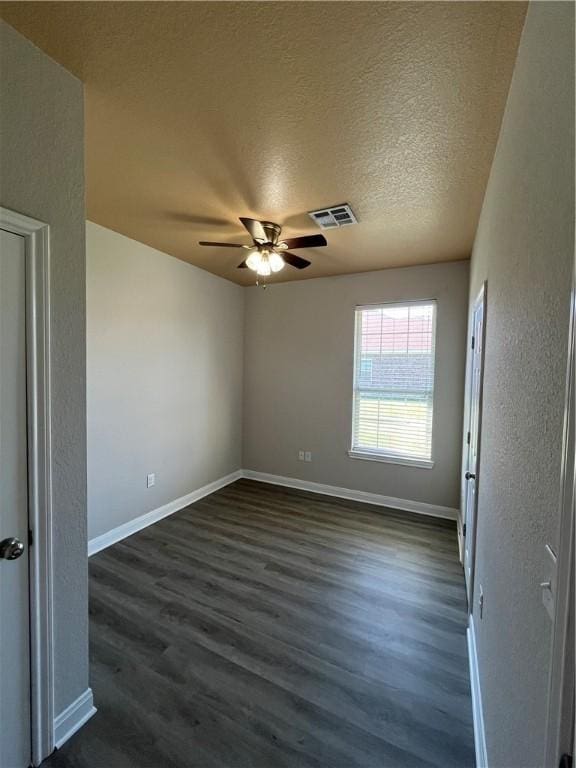 spare room featuring ceiling fan, dark hardwood / wood-style flooring, and a textured ceiling