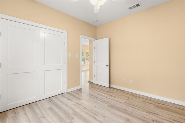 unfurnished bedroom with ceiling fan, a closet, and light hardwood / wood-style floors