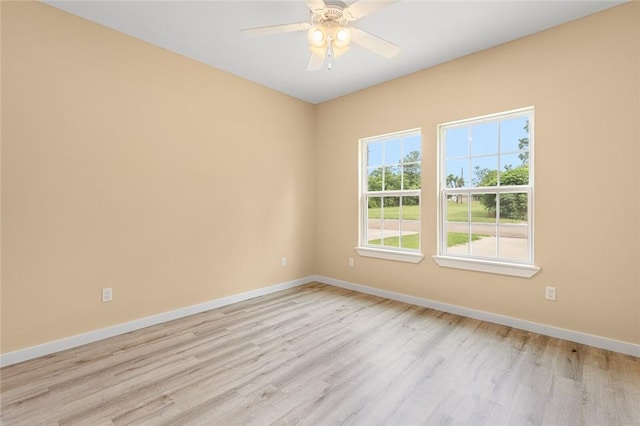 empty room with ceiling fan and light hardwood / wood-style flooring