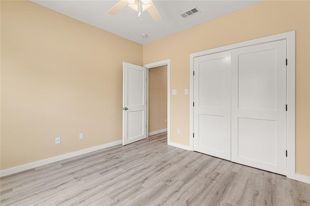 unfurnished bedroom featuring a closet, light hardwood / wood-style floors, and ceiling fan