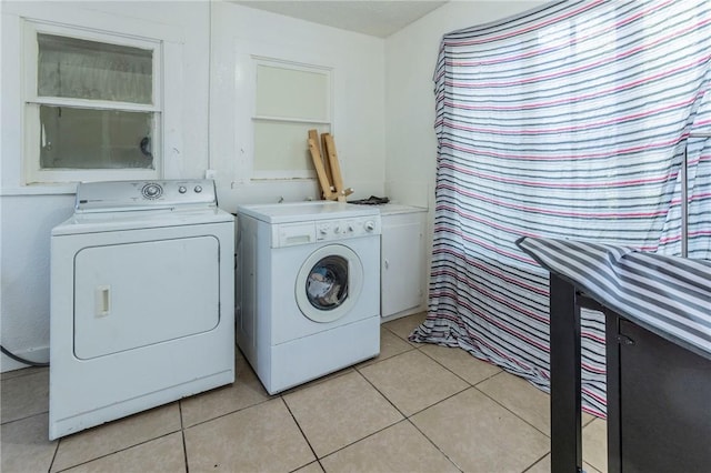 clothes washing area with light tile patterned flooring and independent washer and dryer