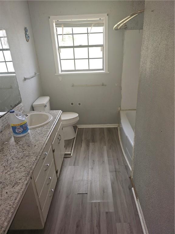 full bathroom featuring shower / bath combination, vanity, wood-type flooring, and toilet