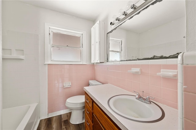 full bathroom with vanity, bathing tub / shower combination, toilet, tile walls, and wood-type flooring