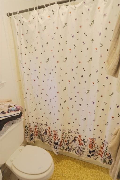 full bathroom with toilet, a shower with curtain, and tile patterned flooring