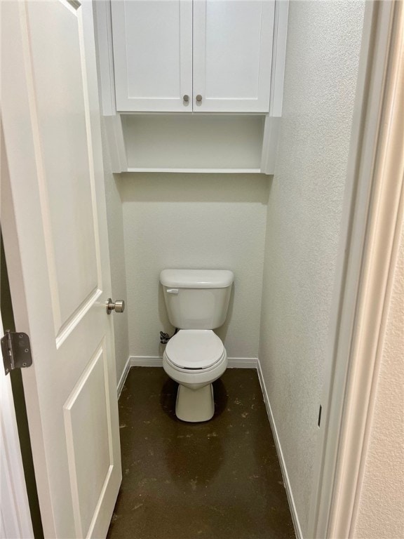 bathroom with toilet and concrete floors