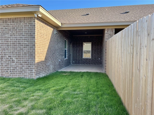 entrance to property featuring a patio area and a yard