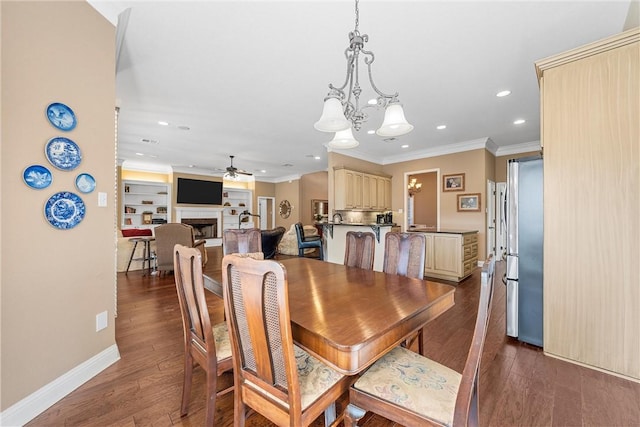 dining room with ceiling fan with notable chandelier, ornamental molding, built in features, and dark wood-type flooring