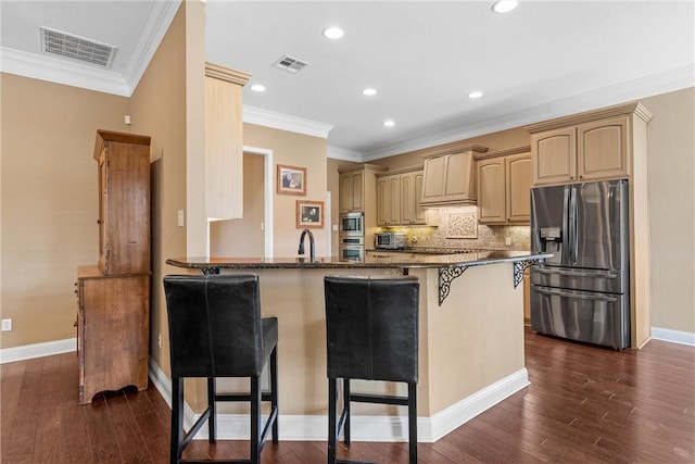 kitchen with a kitchen breakfast bar, stainless steel appliances, crown molding, kitchen peninsula, and tasteful backsplash