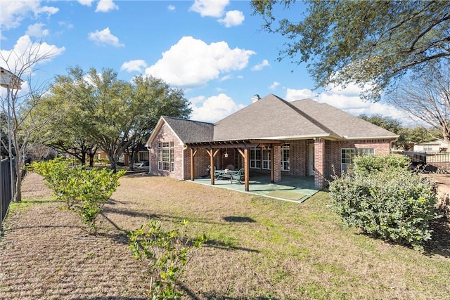 rear view of house featuring a patio and a yard