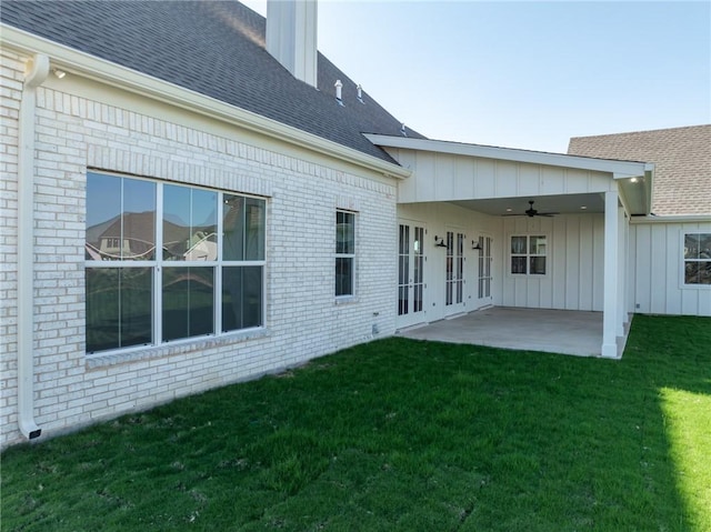 rear view of house with ceiling fan, a patio area, and a lawn