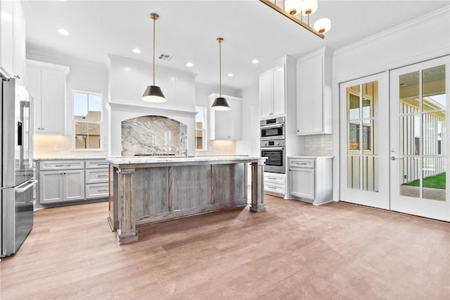 kitchen featuring pendant lighting, white cabinetry, a wealth of natural light, and french doors