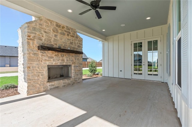 view of patio / terrace featuring an outdoor stone fireplace, ceiling fan, and french doors