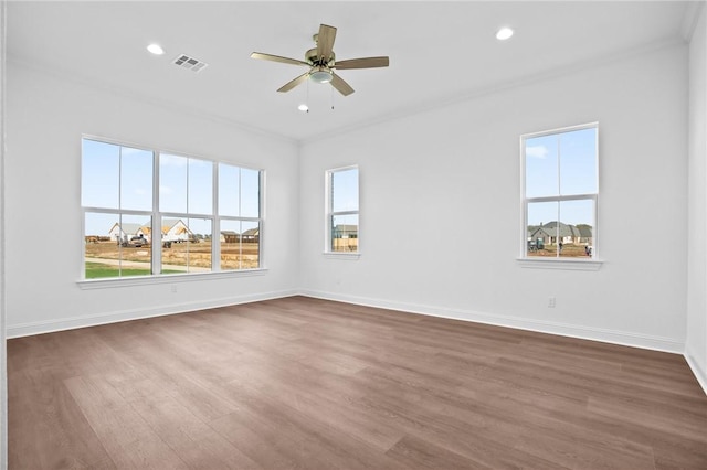 unfurnished room featuring dark hardwood / wood-style floors, plenty of natural light, ornamental molding, and ceiling fan