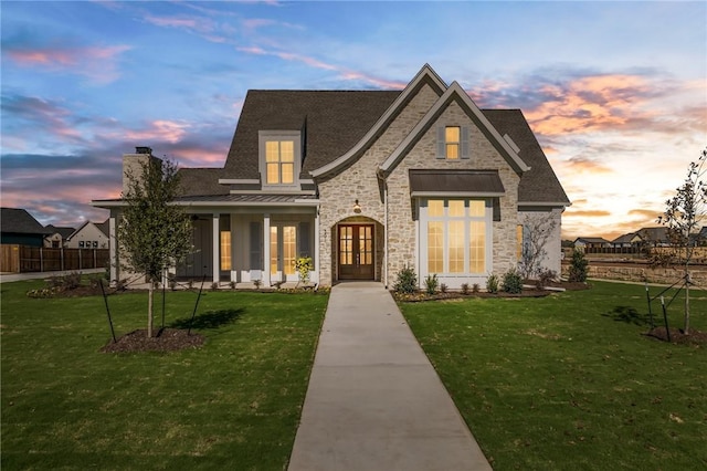 view of front of home featuring a lawn and french doors