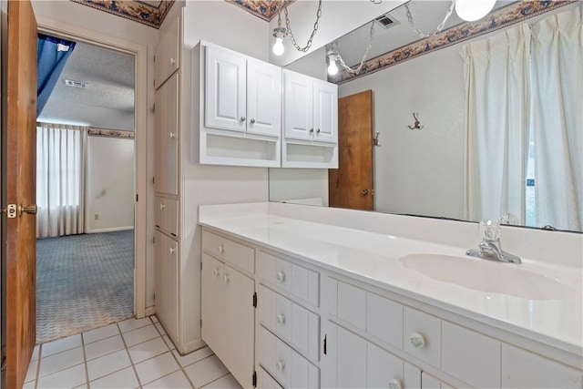 bathroom with tile patterned flooring, vanity, and a textured ceiling